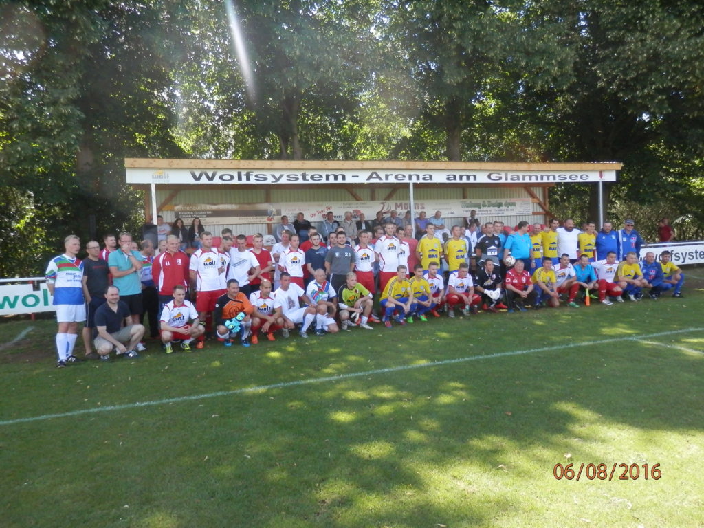 © Uwe Kolbusa Zum gemeinsamen Erinnerungsfoto an die Namenseinweihung der Wolfsystemarena am Glammsee, stellten sich alle Mannschaften, Sponsoren und Zuschauer.